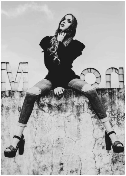 girl sitting on concrete wall poster